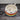 Ceramic bowl with rainbow stripes and black heart designs on a wooden surface.