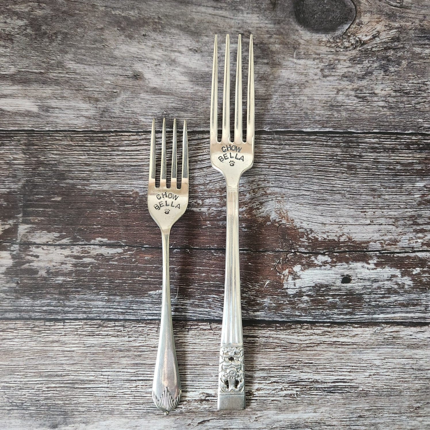 Two silver forks on a wooden surface