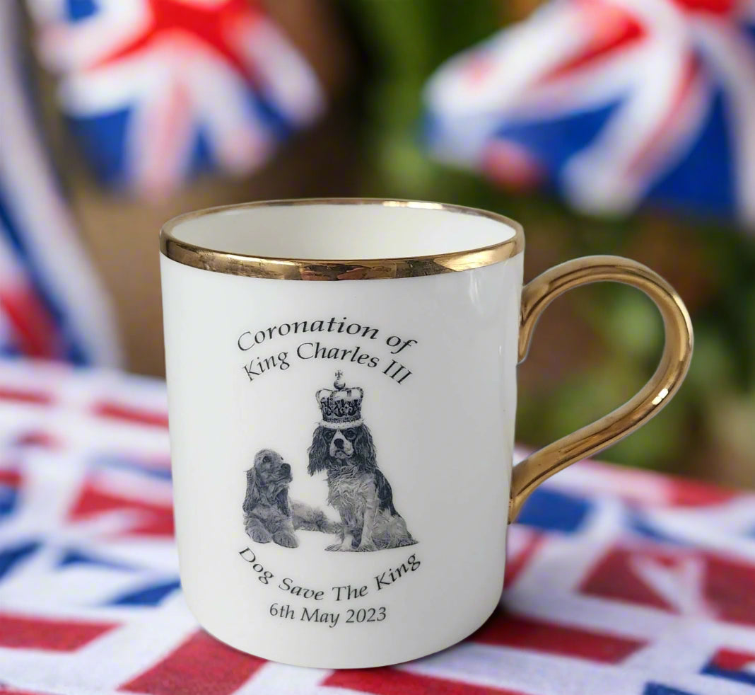 Mug with gold rim and handle featuring text and images related to King Charles III's coronation.